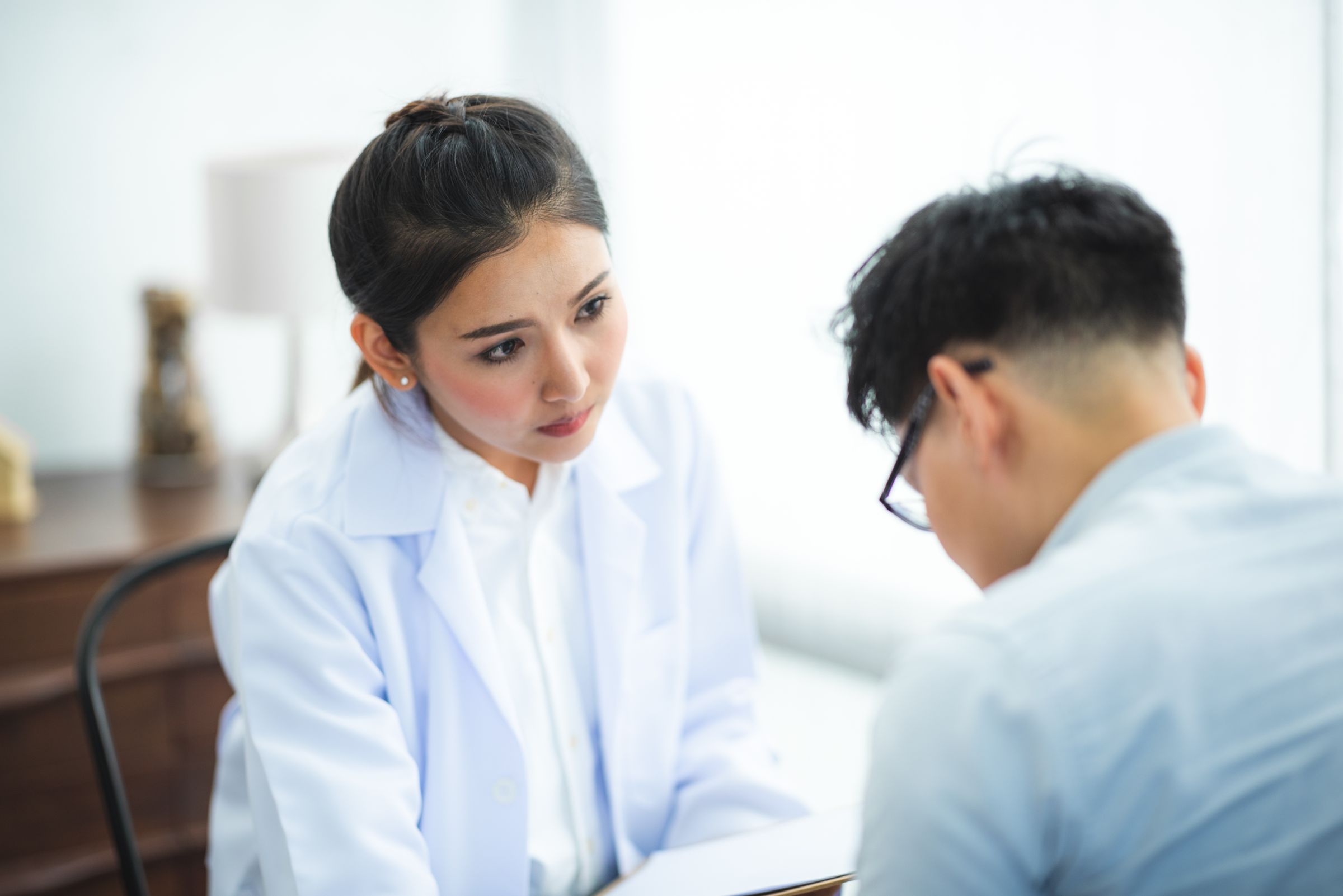 Doctor in a white coat consulting with a patient.