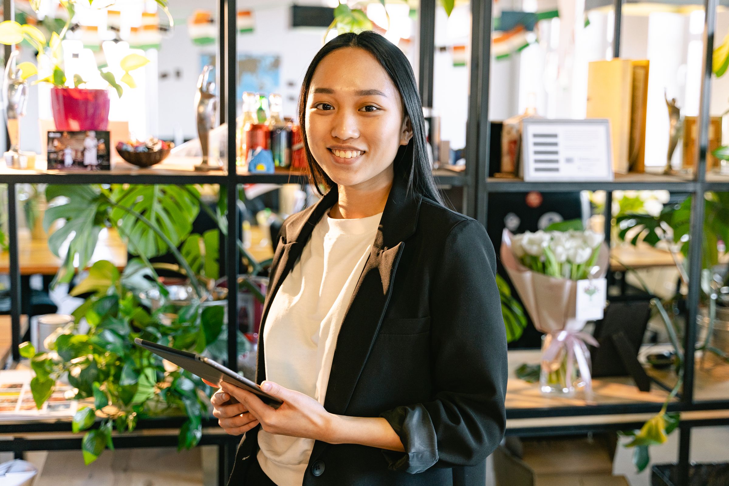 Smiling professional holding a tablet in a modern office.