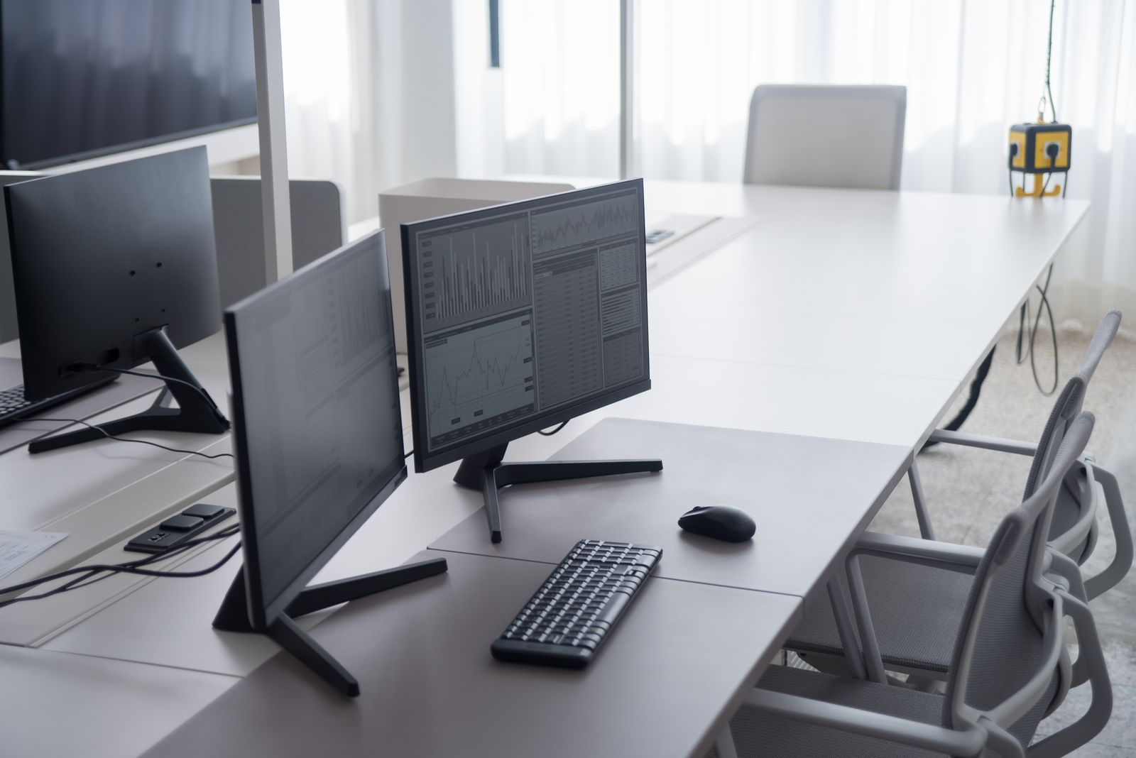 Twin monitors on a bright office desk.