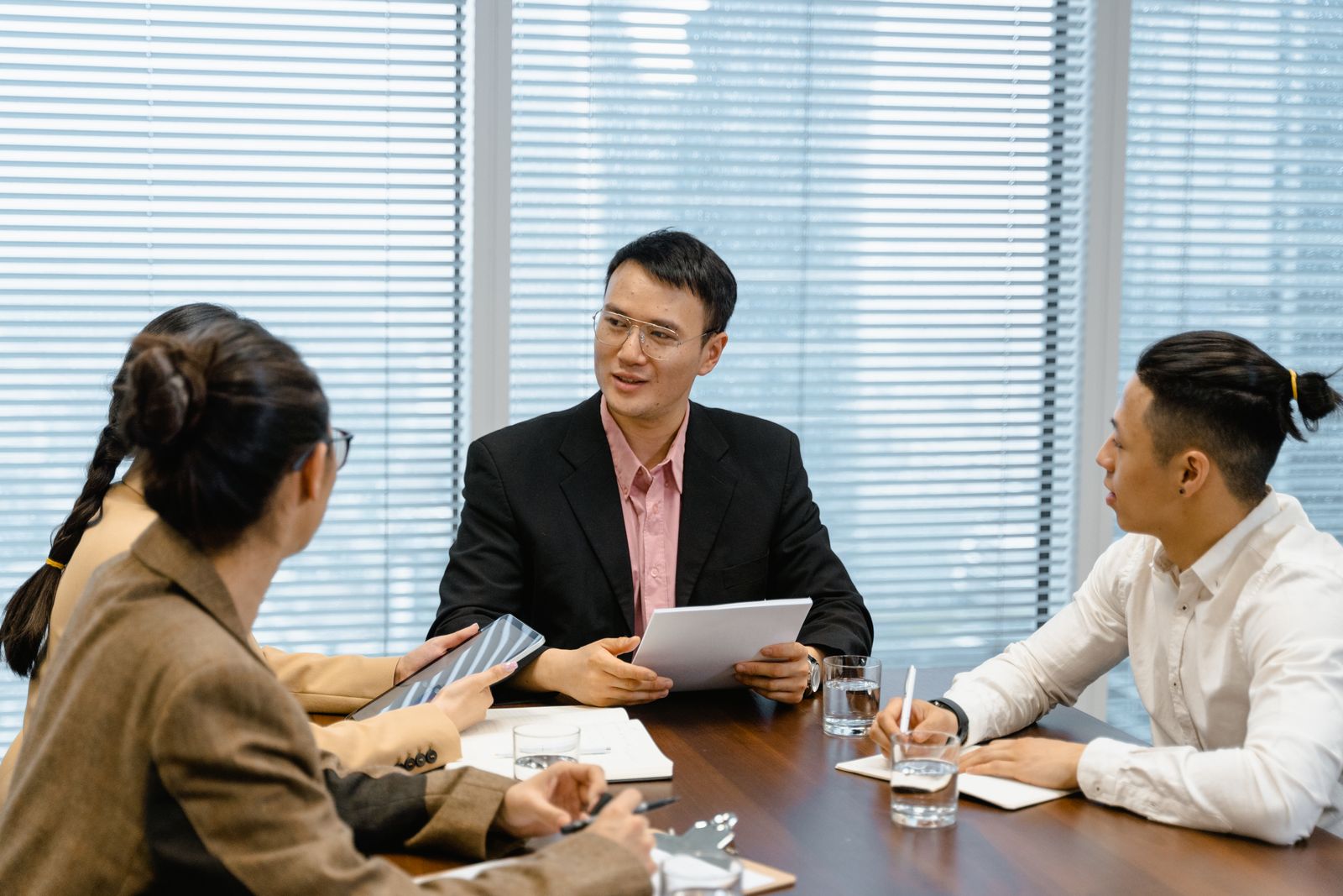Three colleagues walking through a process around a meeting table.