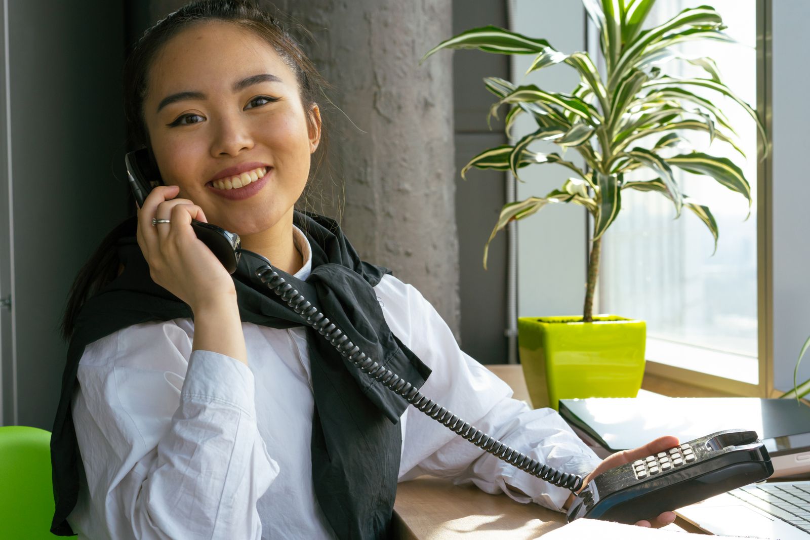 Smiling team member answering a call at her desk.