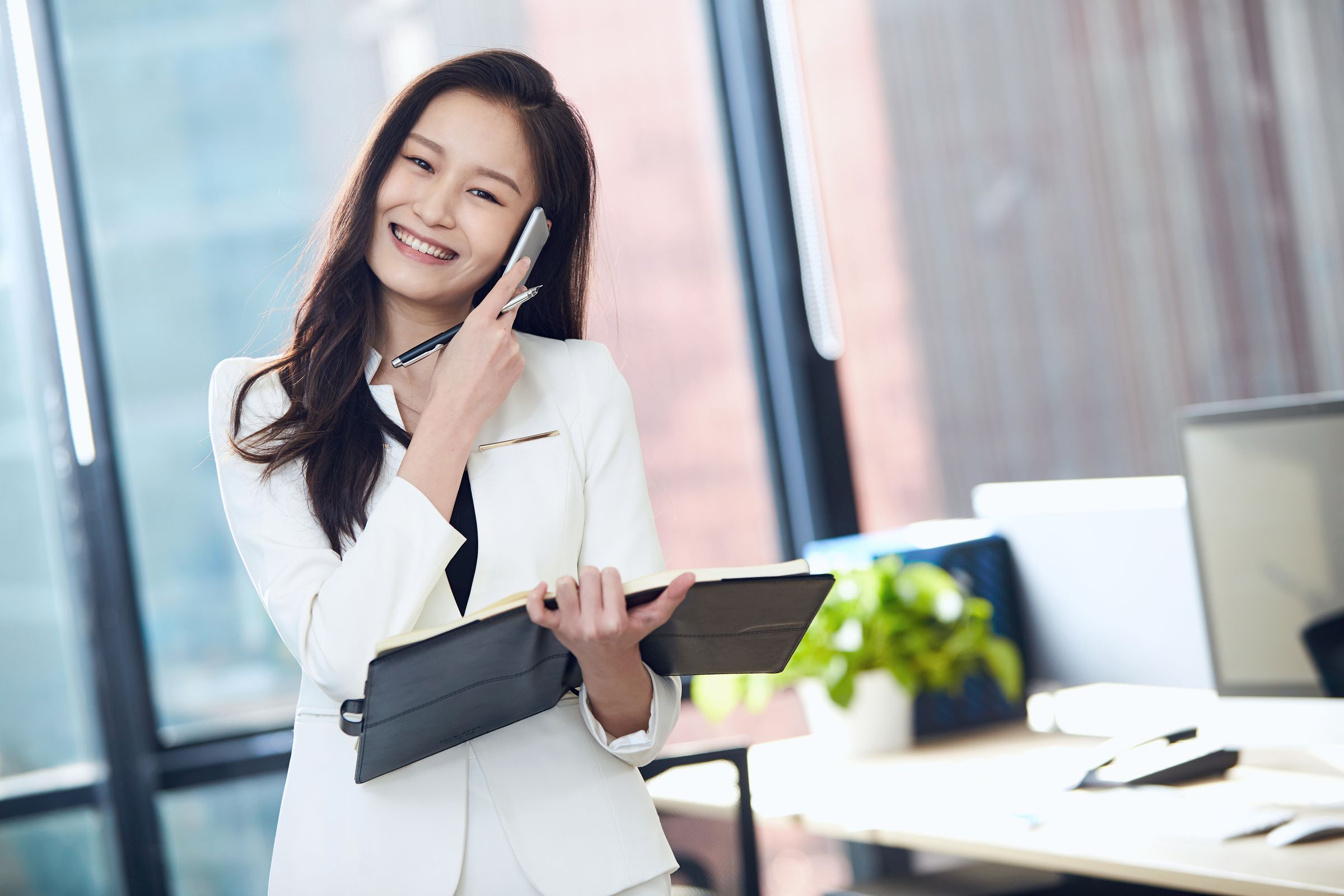 Smiling professional on a call in a bright office.